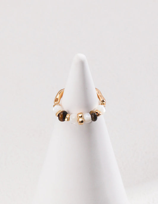 Gold-tone ring with small round white and dark beads along a slim band