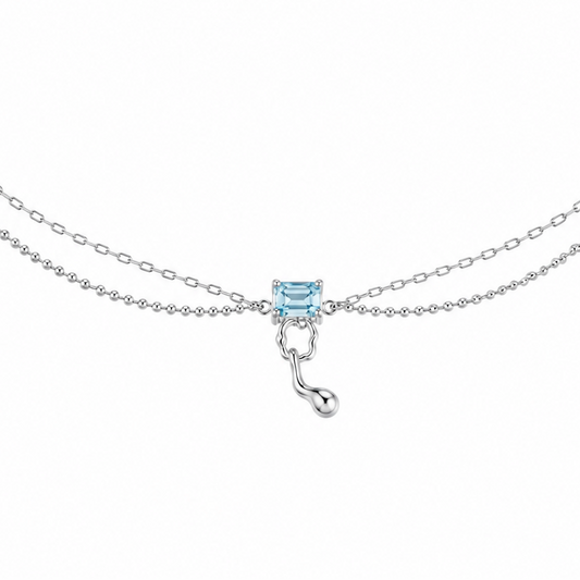 Silver chain necklace with blue square centerpiece and hook-shaped drop charm