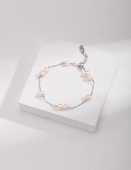 Sterling silver pearl bracelet with round white beads and small dangling charm