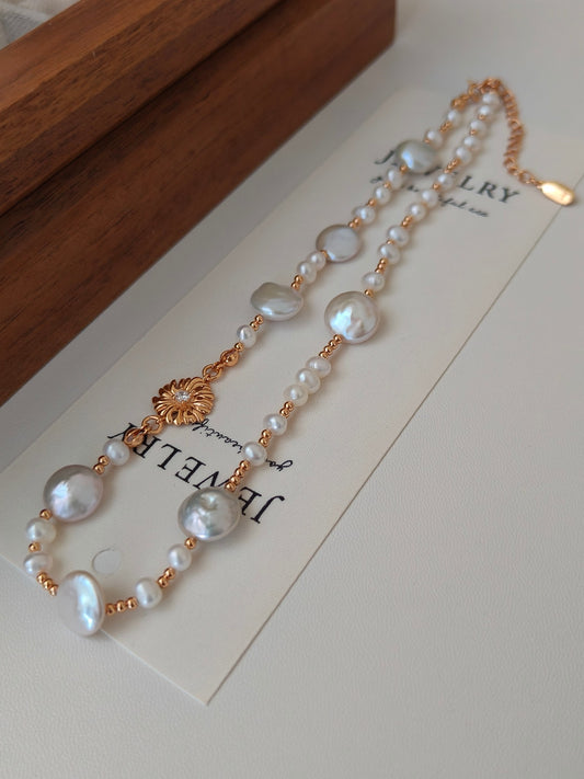 Gold-tone freshwater pearl necklace with multiple pearl strands and floral charm