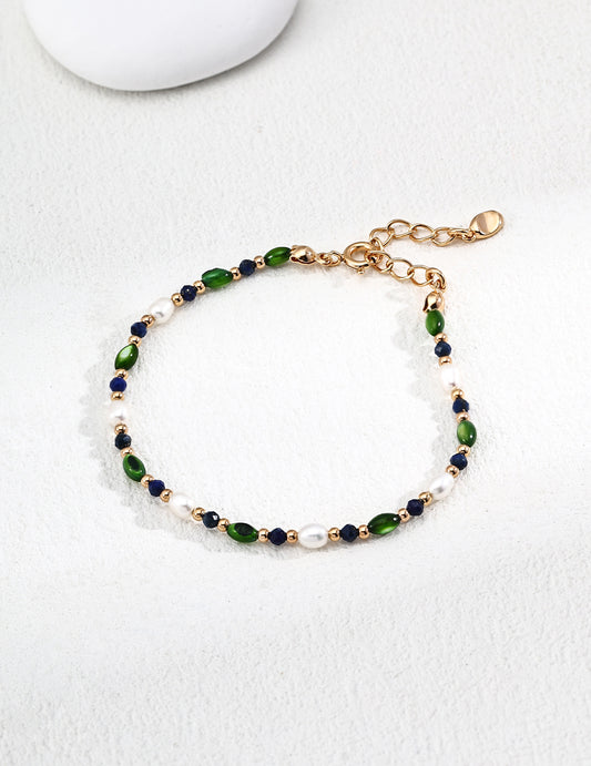 Beaded bracelet with gold links, green and blue beads, and small white pearl accents
