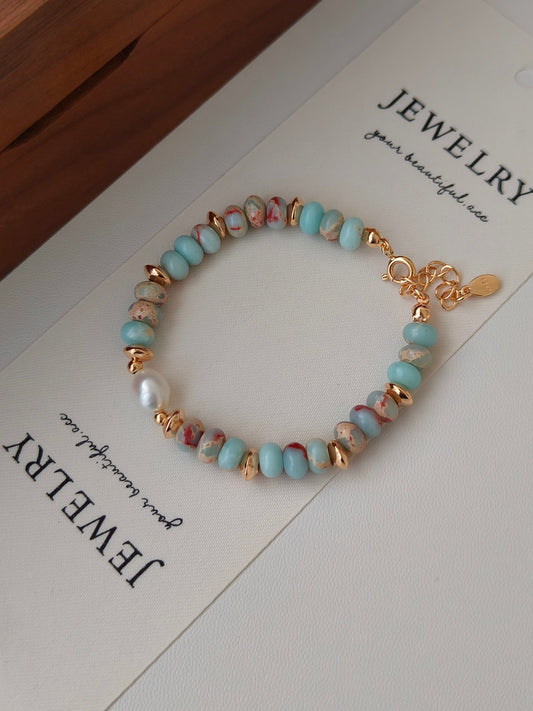 Turquoise stone beaded bracelet with gold-tone chain clasp and white pearl bead accents