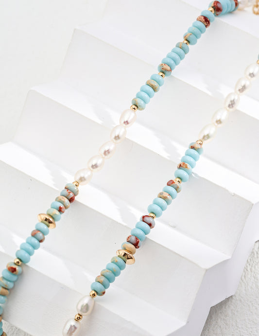 Turquoise heishi-bead strands with freshwater pearls and gold links in close view