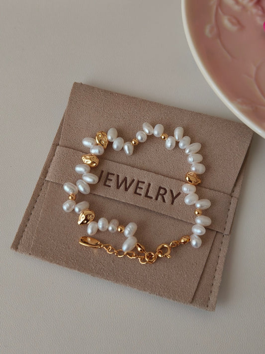 Freshwater pearl bracelet on jewelry card with gold bead accents and charm link