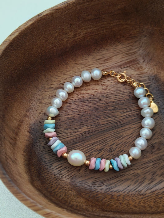 Freshwater pearl bracelet on wooden tray with pastel stone beads and gold clasp