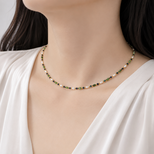 Bead pearl necklace on neckline: green and navy beads with gold-tone highlights