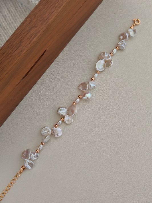 Freshwater pearl bracelet with baroque pearls and gold-tone clasp, laid in a line