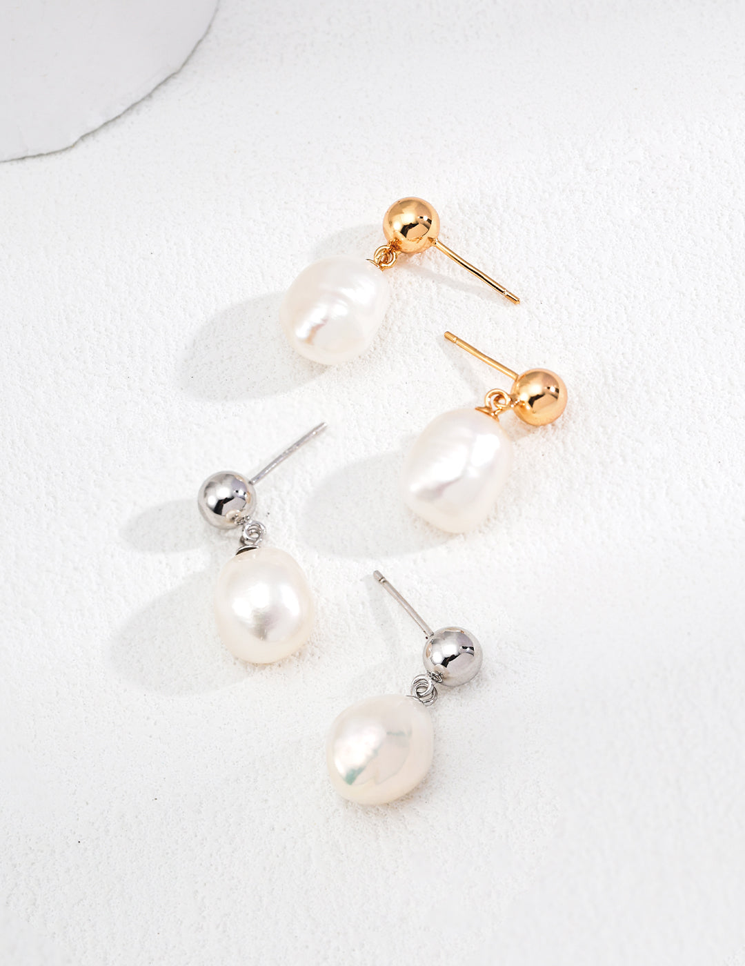 Pearl drop earrings with gold and silver metal accents and teardrop pearls