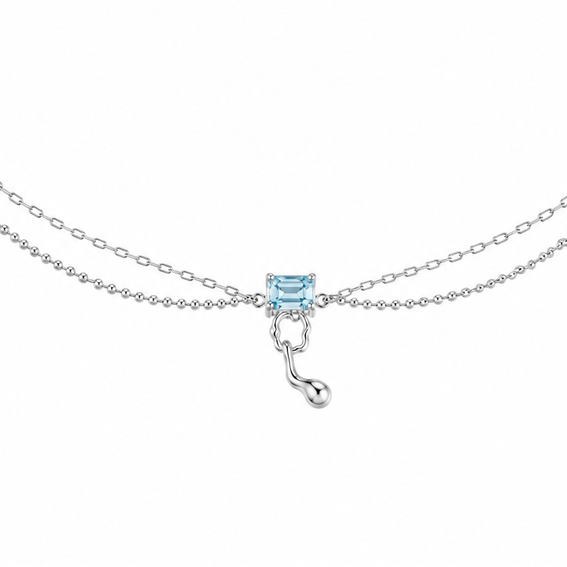 Silver chain necklace with blue square centerpiece and hook-shaped drop charm