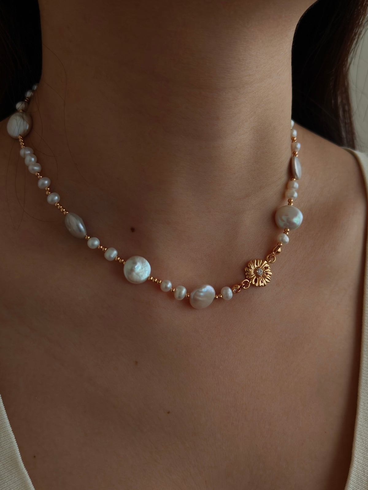Freshwater pearl necklace worn on model with gold floral accents and pearl beads