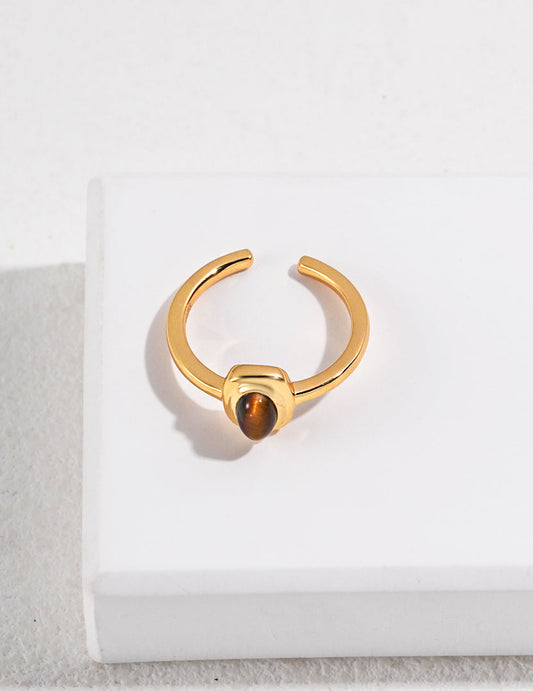 Gold-tone open cuff ring with round tiger eye stone in raised bezel, side view