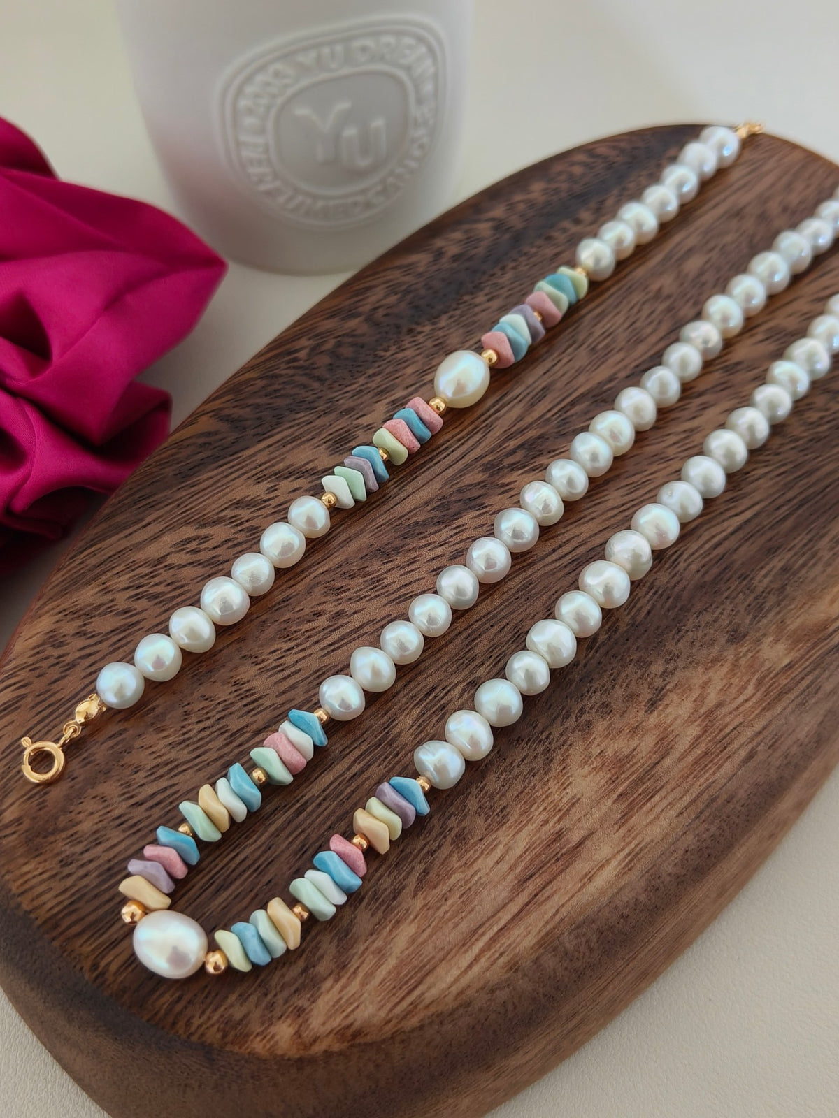Freshwater pearl necklace with pastel rainbow stone beads along the length and gold ends.