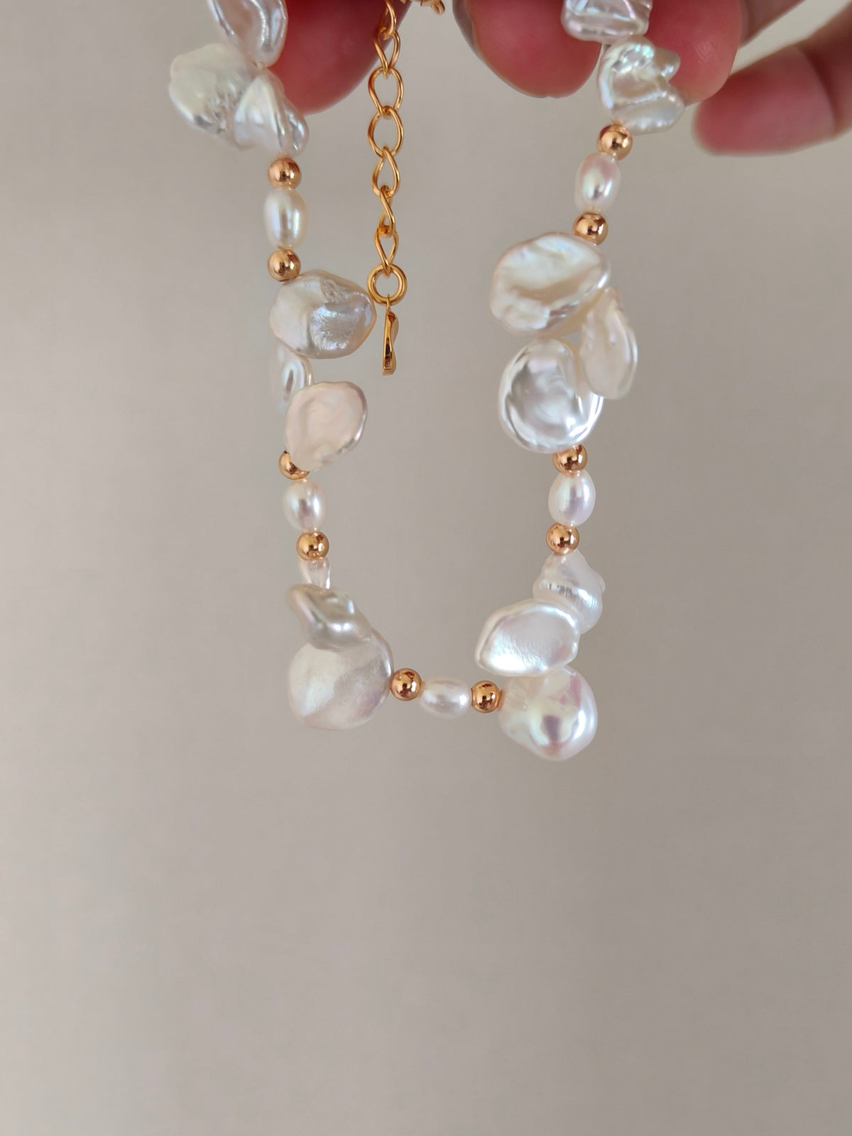 Freshwater pearl bracelet shown close-up with irregular pearls and gold-tone connector links