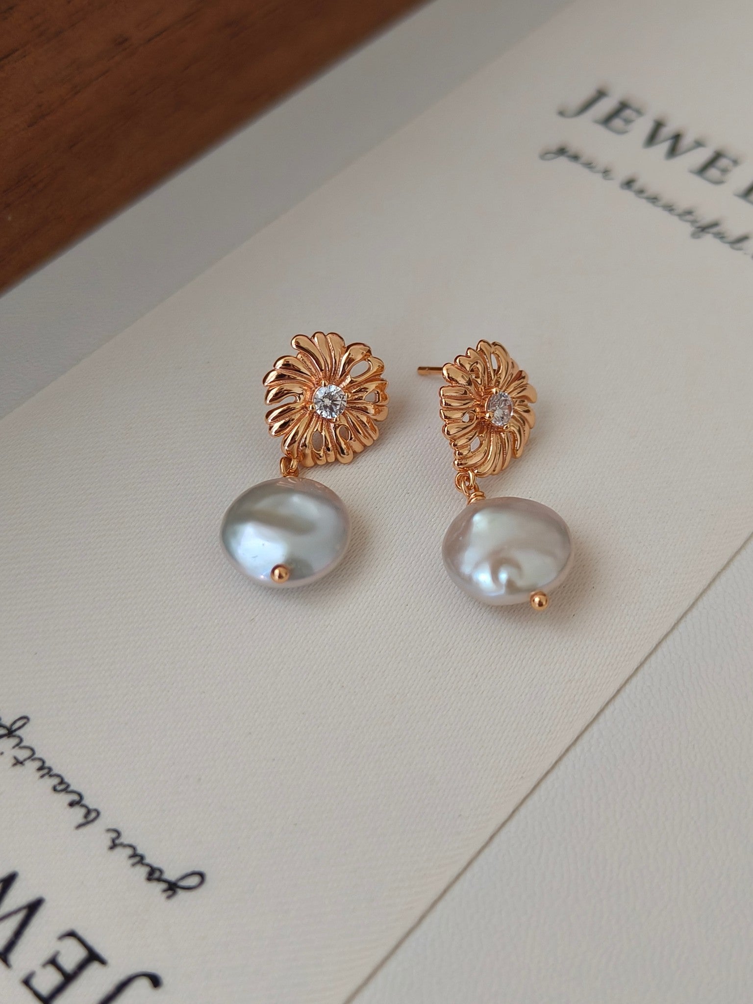 Gold-tone floral pearl drop earrings with crystal centers and round white pearls