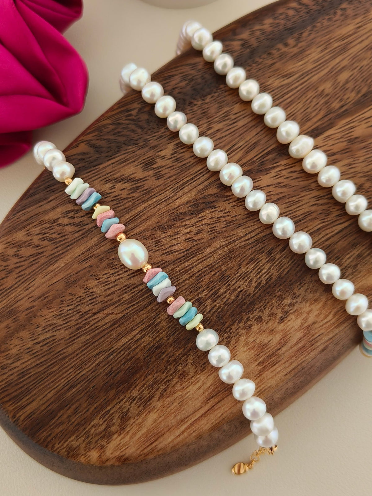 Set of freshwater pearl bracelets with pastel rainbow stone beads on wooden tray