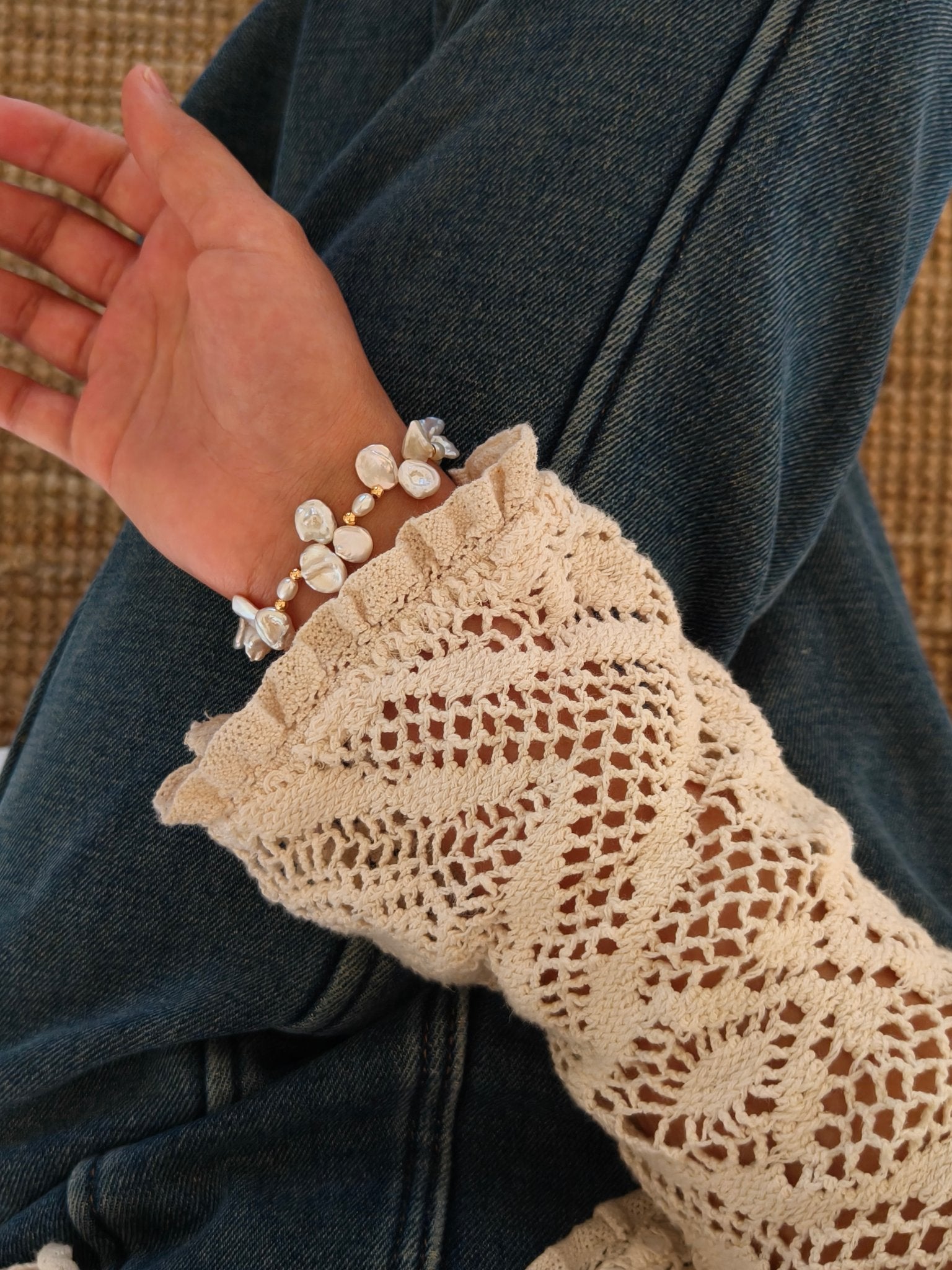 Pearl bracelet on a hand with baroque pearls and gold-tone chain details