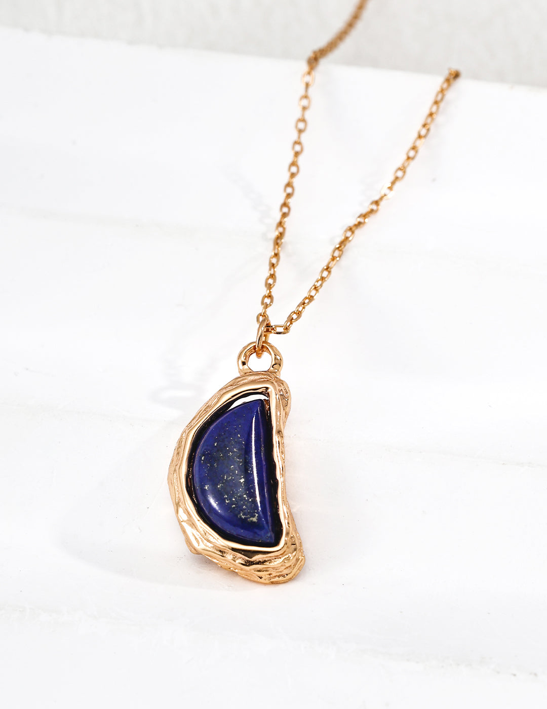 Gold-tone teardrop lapis pendant necklace, front view with hanging chain