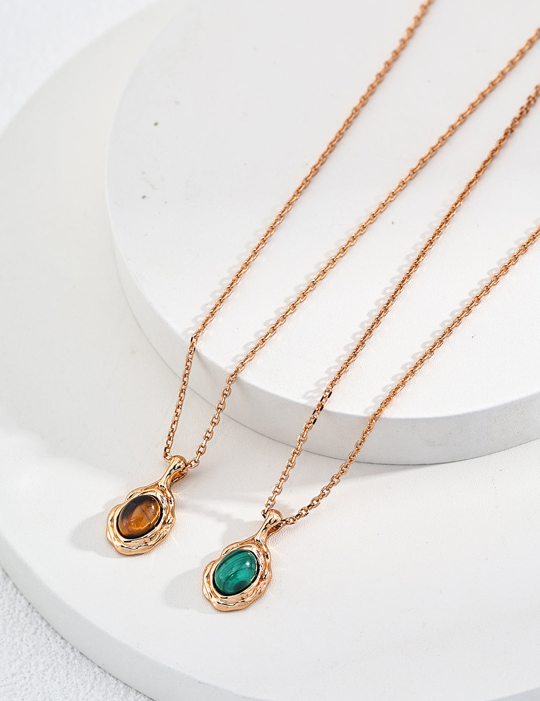 Gold-tone pendant necklace with oval tiger eye and malachite stones in bezels