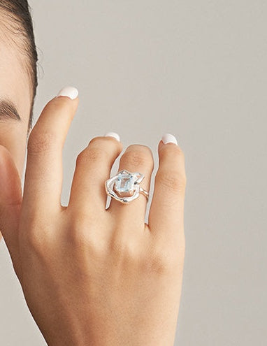 Silver ring with light-blue rectangular gemstone and curled openwork details
