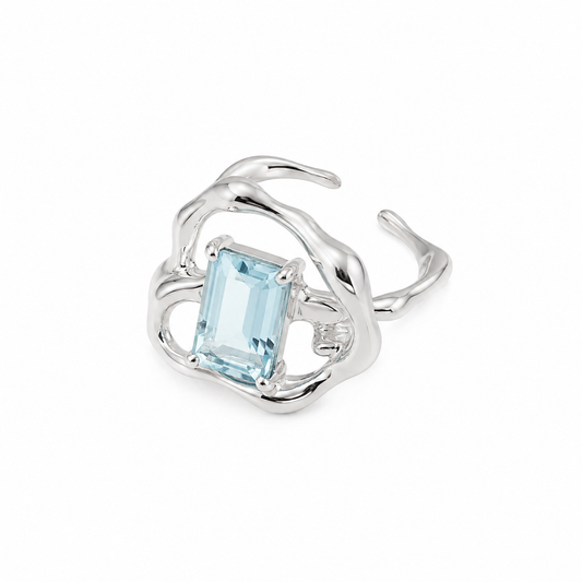 Silver ring with rectangular light-blue gemstone in an ornate swirl setting