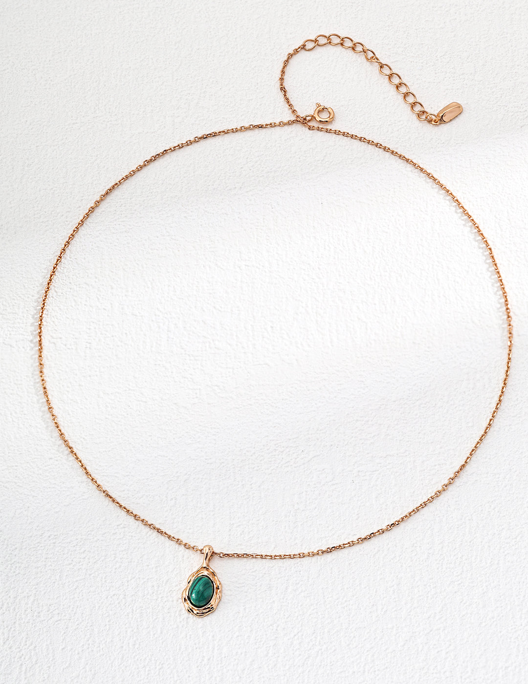 Gold-tone pendant necklace with oval green stone on thin chain
