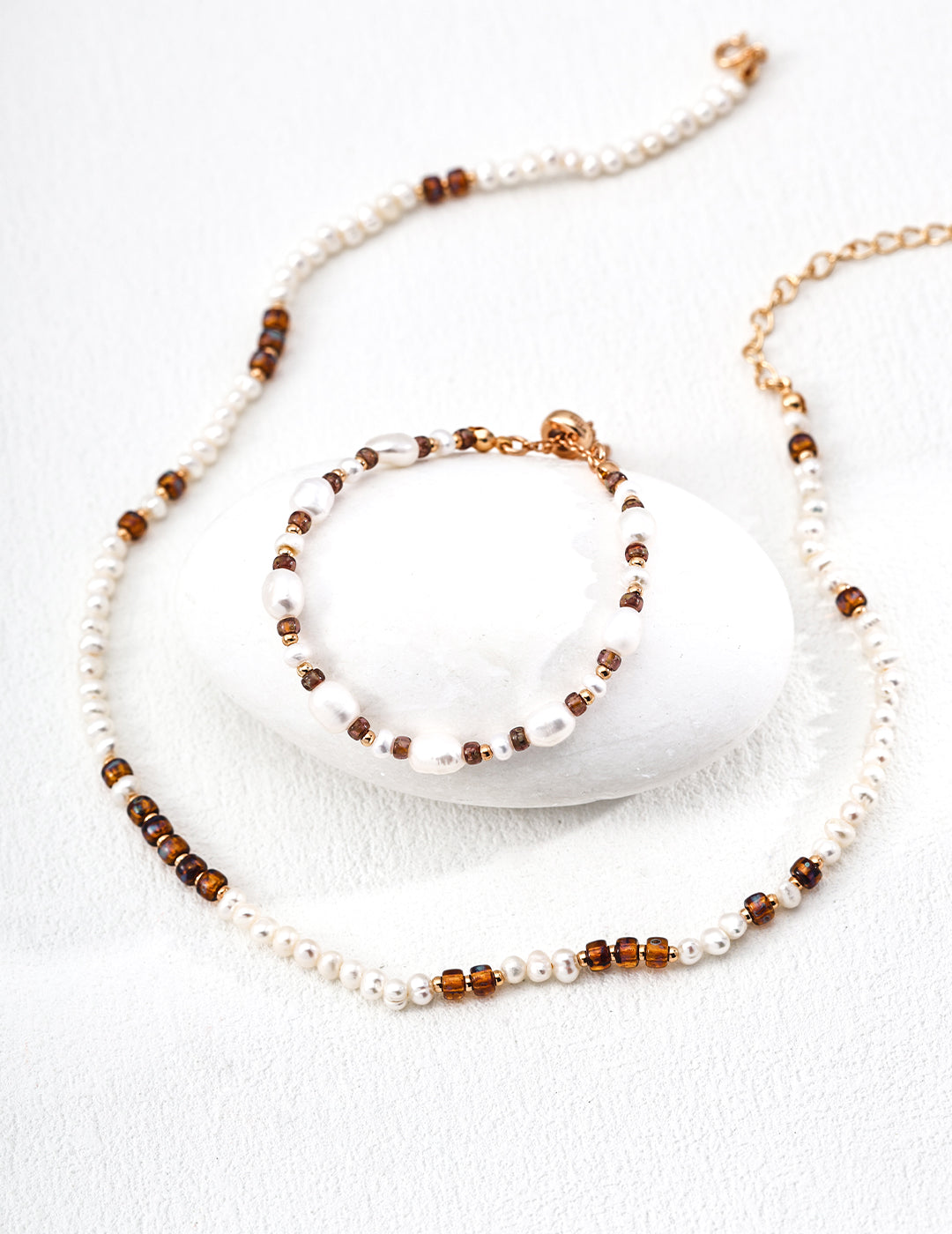 Pearl and amber bead necklace with gold links, shown with bracelet in frame