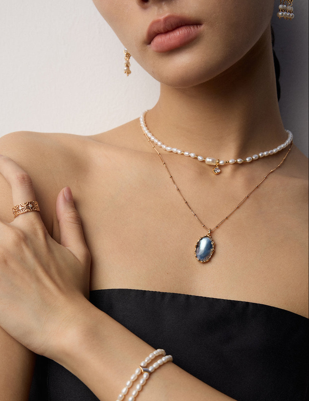 Mabe pearl pendant necklace on model with oval blue pearl pendant and gold chain