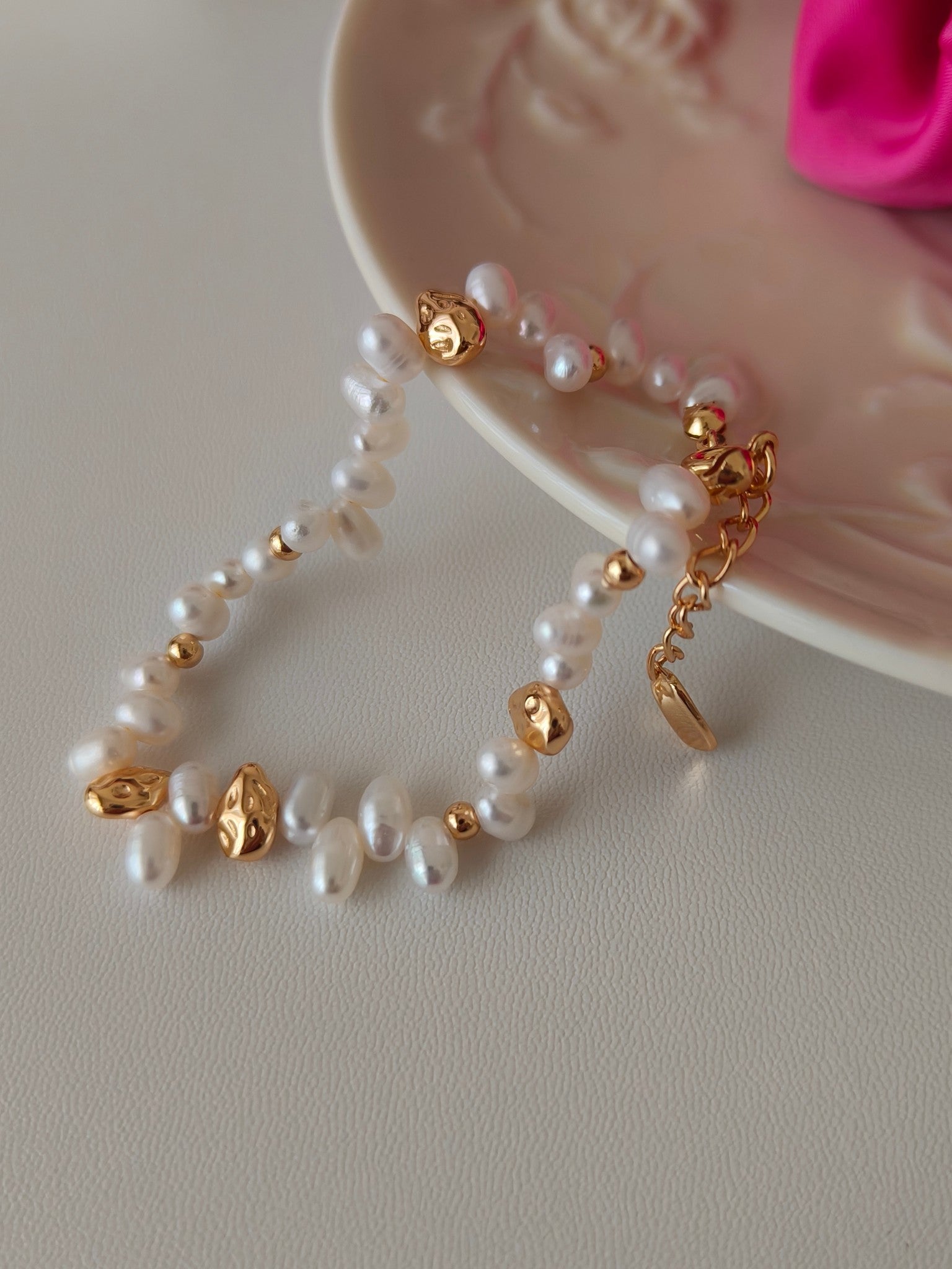 Freshwater pearl bracelet with gold bead stations and dangling charm links