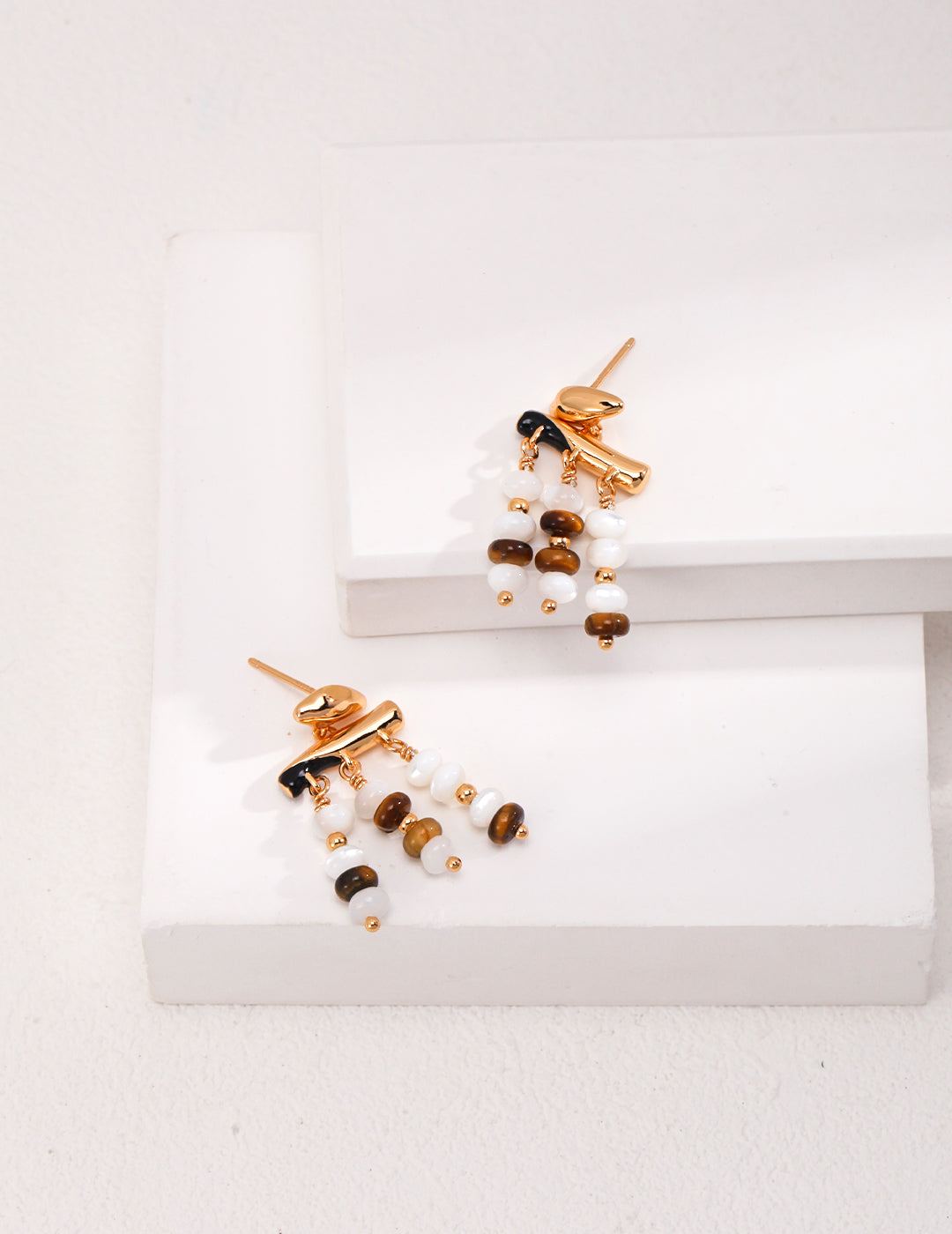 Gold-tone drop earrings with white pearl and tiger eye bead rows