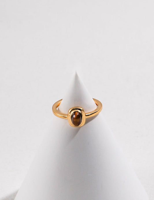 Gold-tone open ring with round tiger eye cabochon centered in bezel, top view