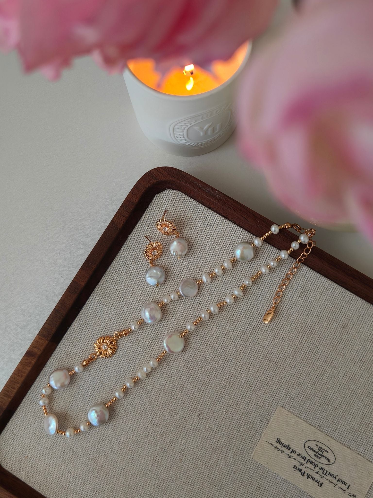Freshwater pearl necklace set on tray with gold floral charms and pearl beads