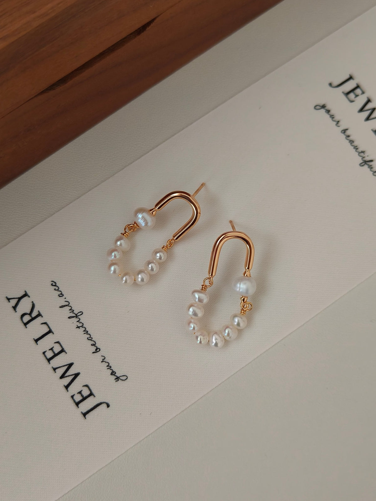Rose gold hoop earrings with dangling pearl clusters and small gold bead accents