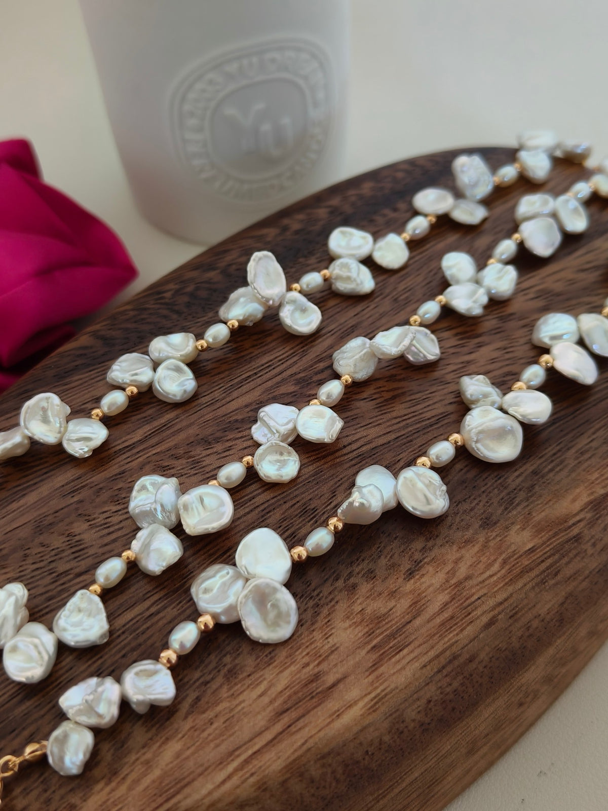 Freshwater pearl necklace on wooden tray with baroque pearls and gold bead accents