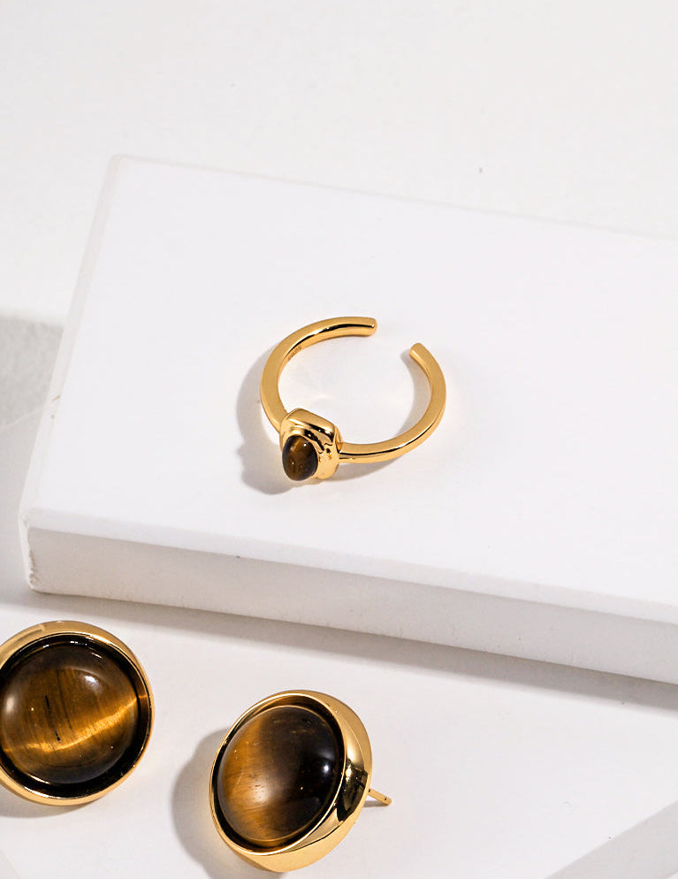 Gold-tone tiger eye ring on white display box, round stone bezel and open shank