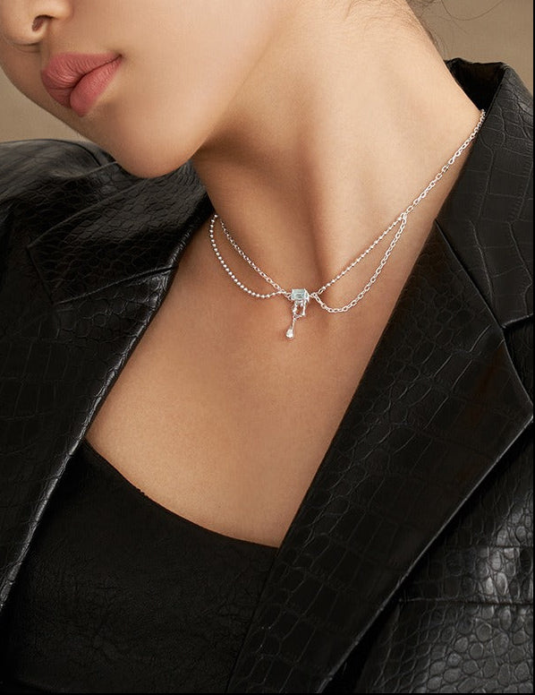 Silver layered chain necklace with light blue square pendant and hook drop charm