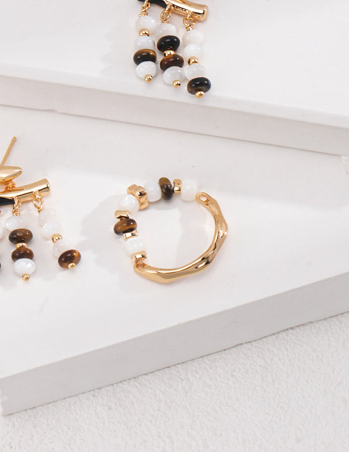 Gold-tone ring with round white beads and dark beads, arched profile
