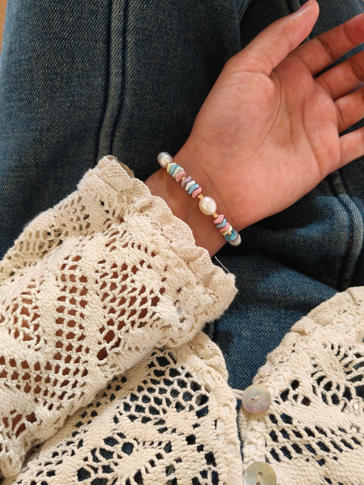 Freshwater pearl bracelet on hand with pastel rainbow stone beads and pearl beads