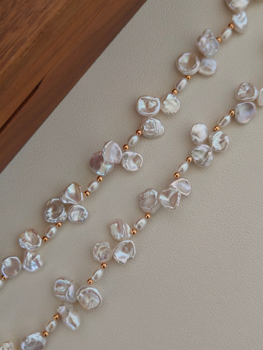 Freshwater pearl necklace close-up with oval baroque pearls and gold bead spacers