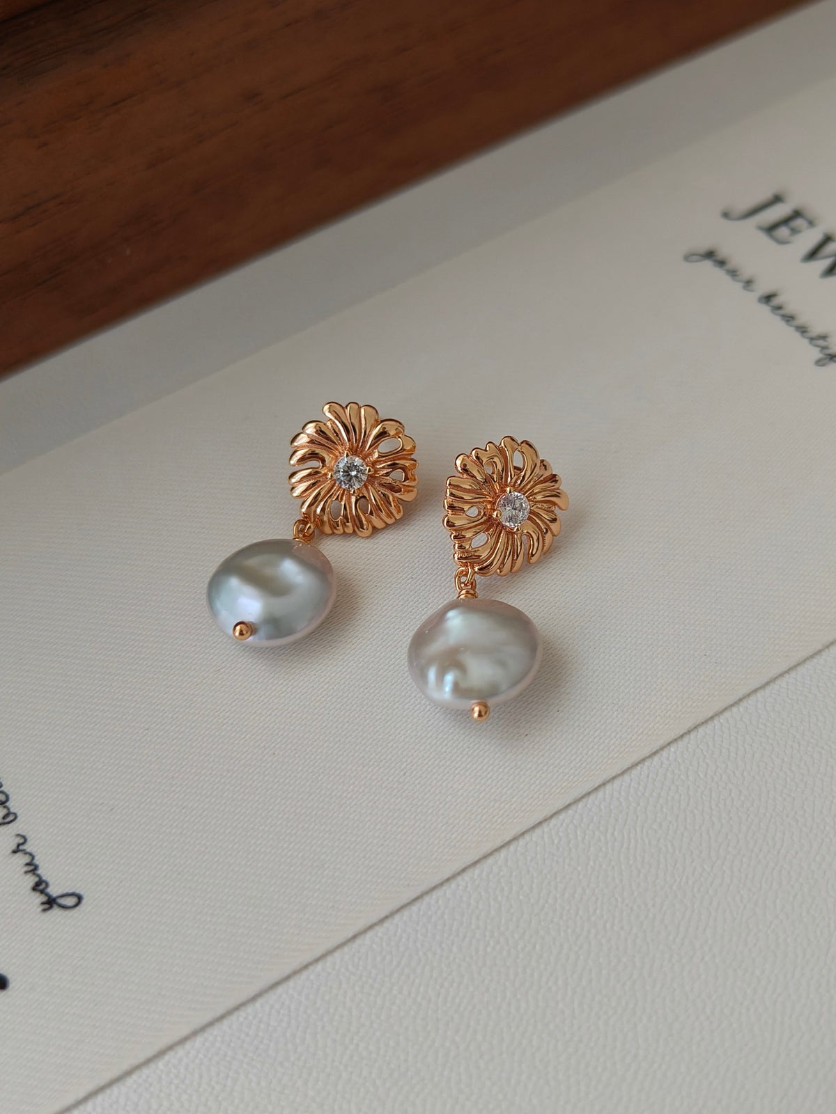 Gold-tone floral pearl drop earrings with crystal studs and oval white pearls