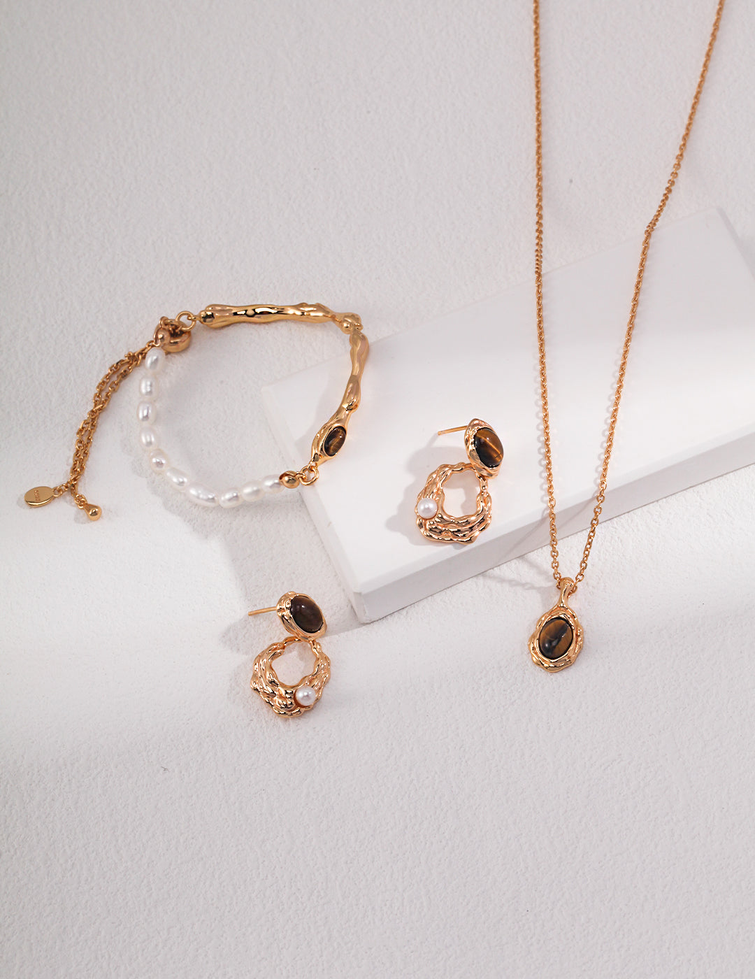 Assorted gold-tone pendants: oval stone necklace plus matching charm pieces