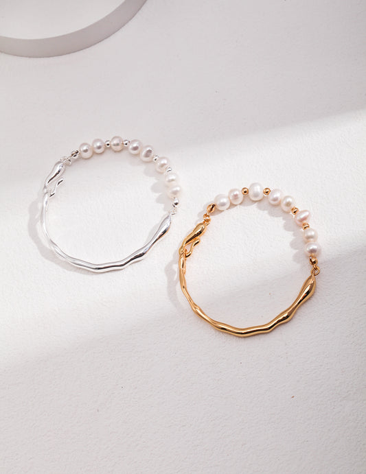 Pair of pearl bracelets with wavy chain links, one gold-tone and one silver-tone