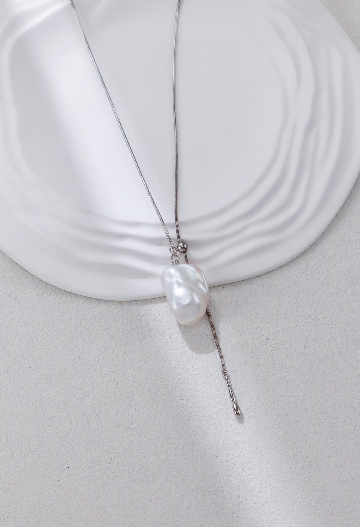 Silver adjustable baroque pearl pendant necklace with thin chain and tassel end