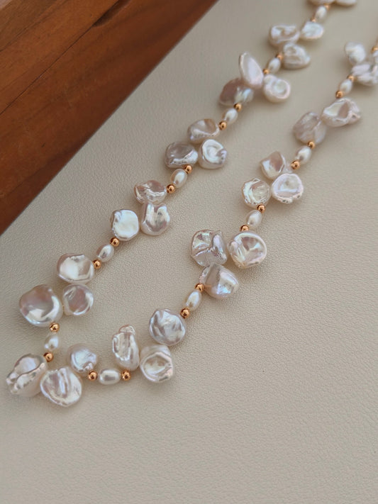 Freshwater pearl necklace close-up showing linked pearl clusters with gold bead details