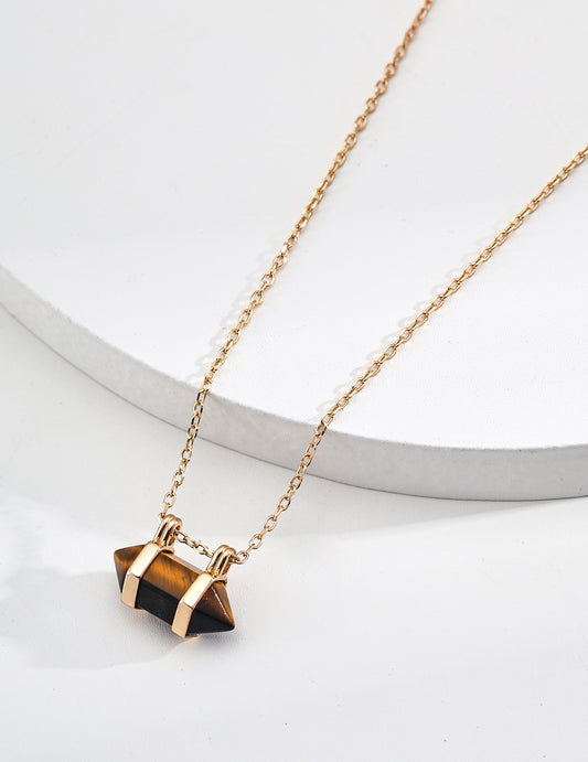 Gold chain necklace featuring a small dark geometric stone pendant charm