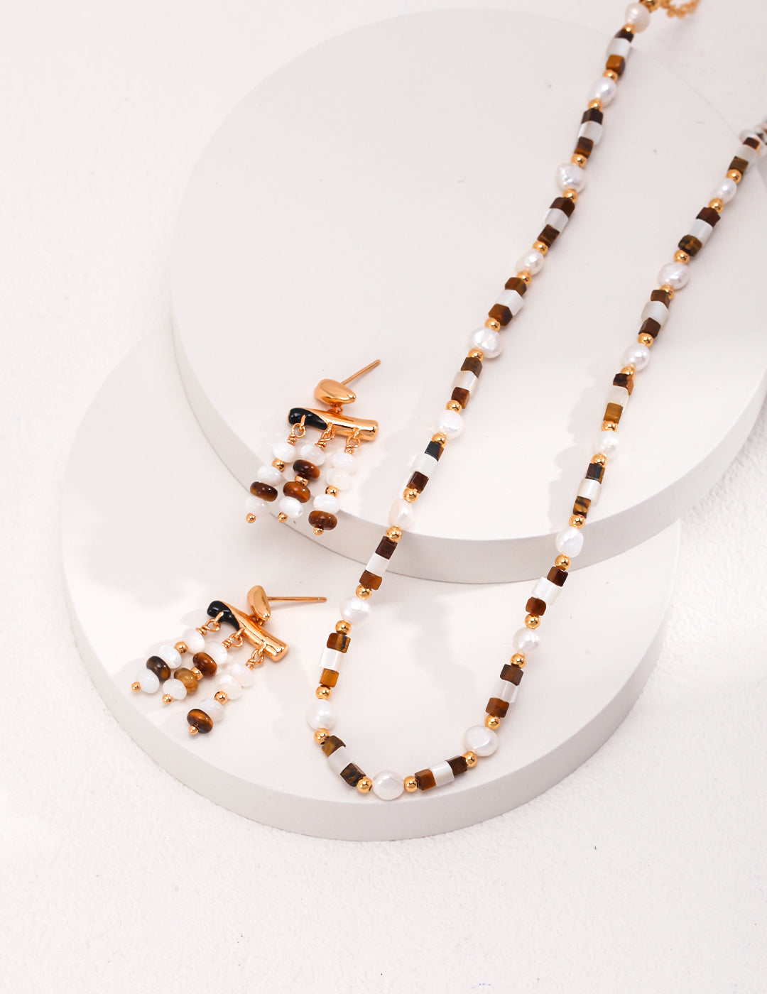 Gold-tone stud earrings with white pearls and tiger eye bead clusters