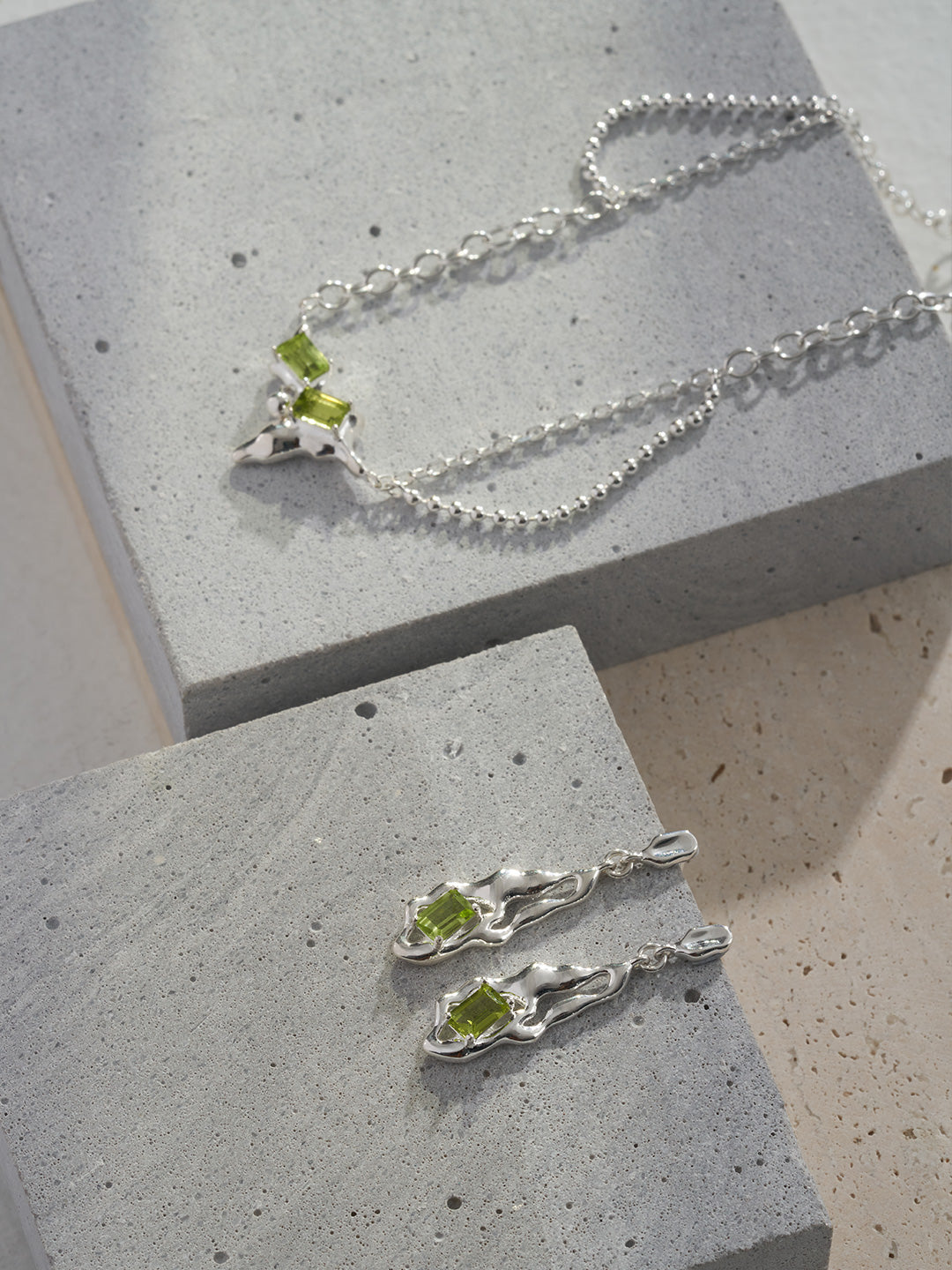 Peridot green gemstone earrings with silver wavy frames and hook backs