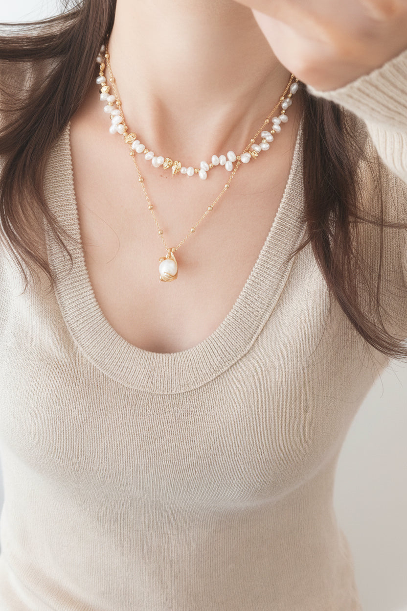 Layered freshwater pearl necklace with gold-tone links and small pearl drop charms