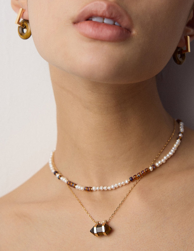 Pearl and bead strand necklace with a gold geometric pendant charm