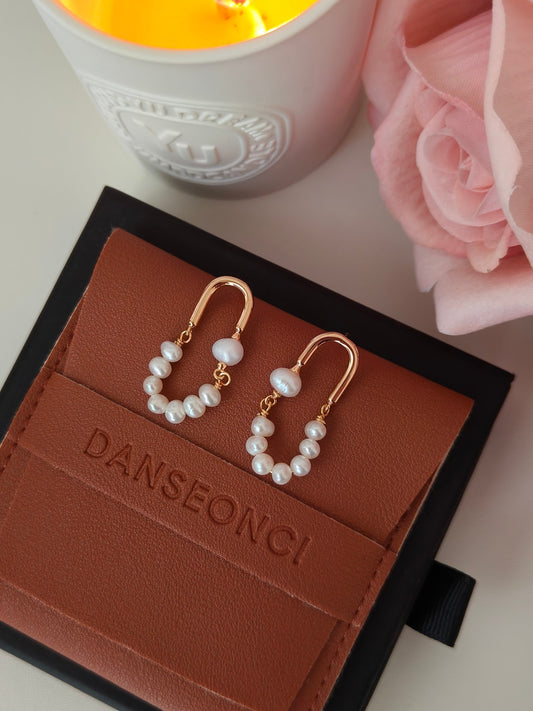 Pearl hoop earrings in rose gold tone with white bead strands and gold charm details