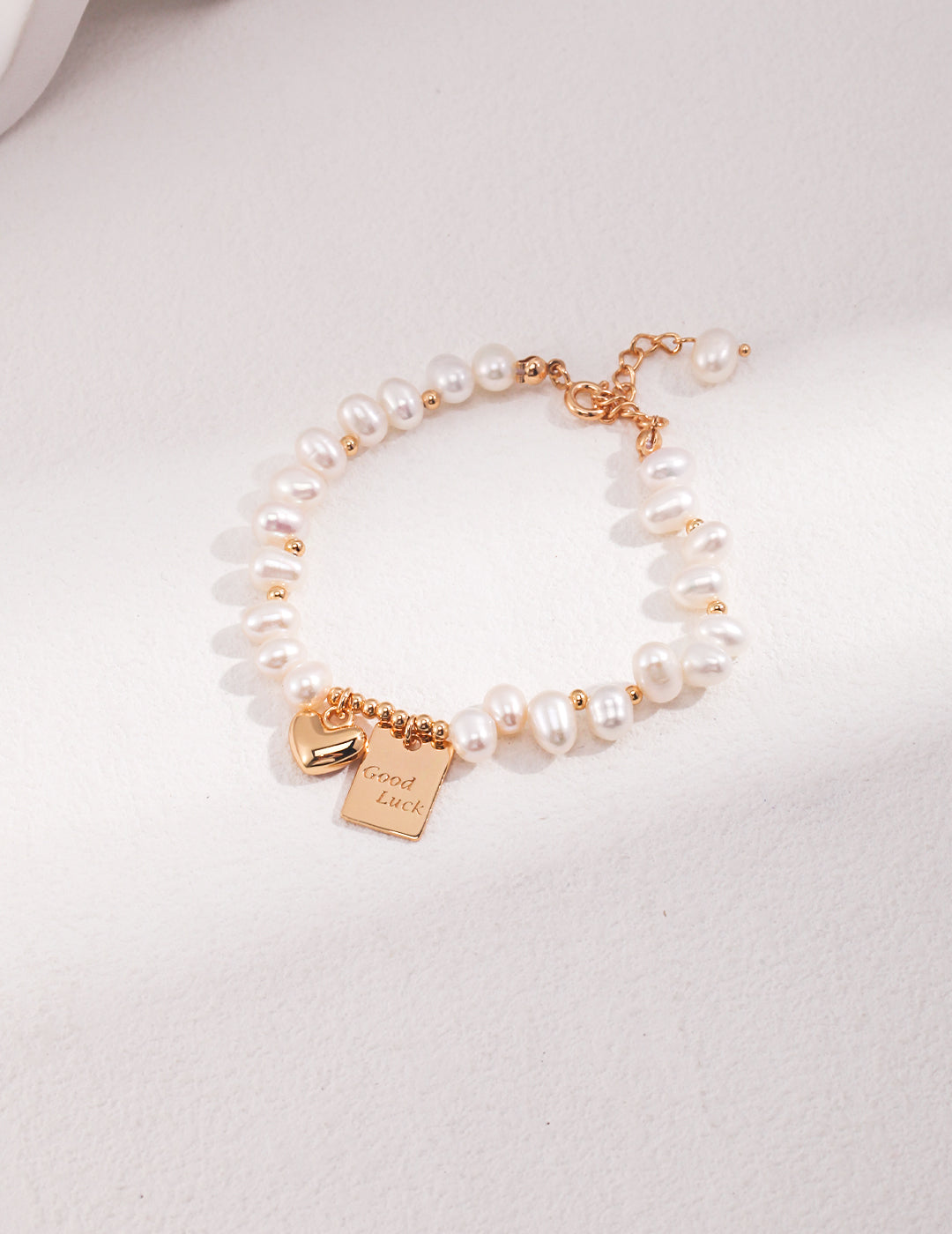 Pearl bracelet with gold-tone Good Luck charm and adjustable chain